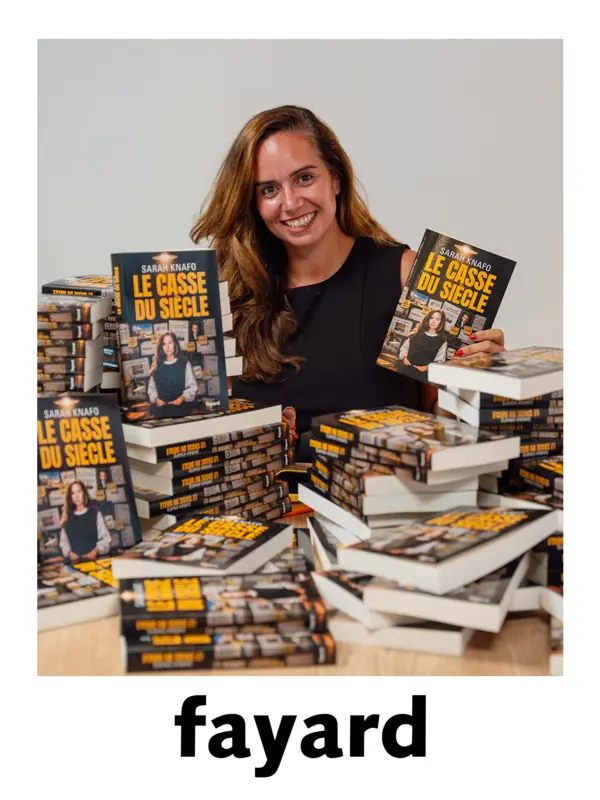 Sarah Knafo derrière des piles du Casse du siècle, un exemplaire à la main, le jour de la livraison.